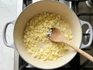 Diced onion softening in melted butter in a Dutch oven